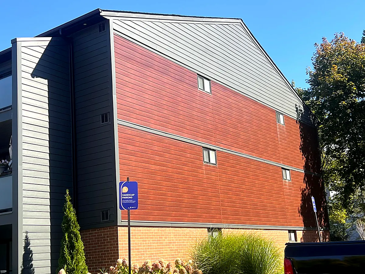 Multi-unit building finished in red and grey aluminum siding